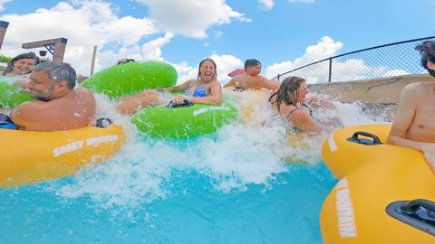 group of people splashing in wave river